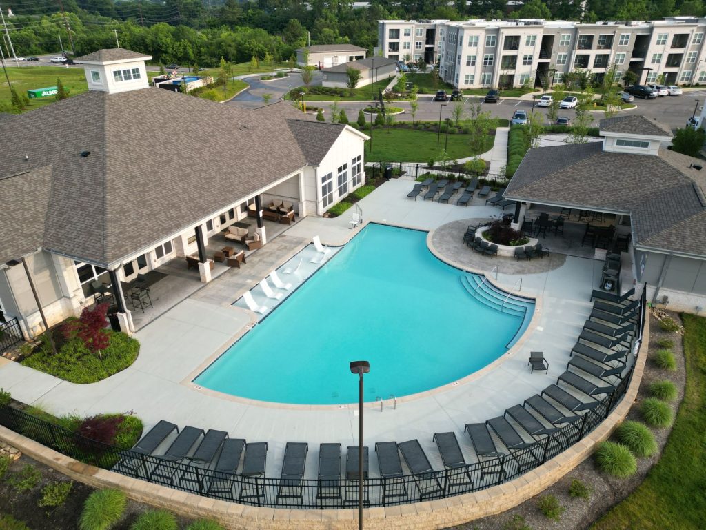 Aerial view of an apartment community pool and clubhouse