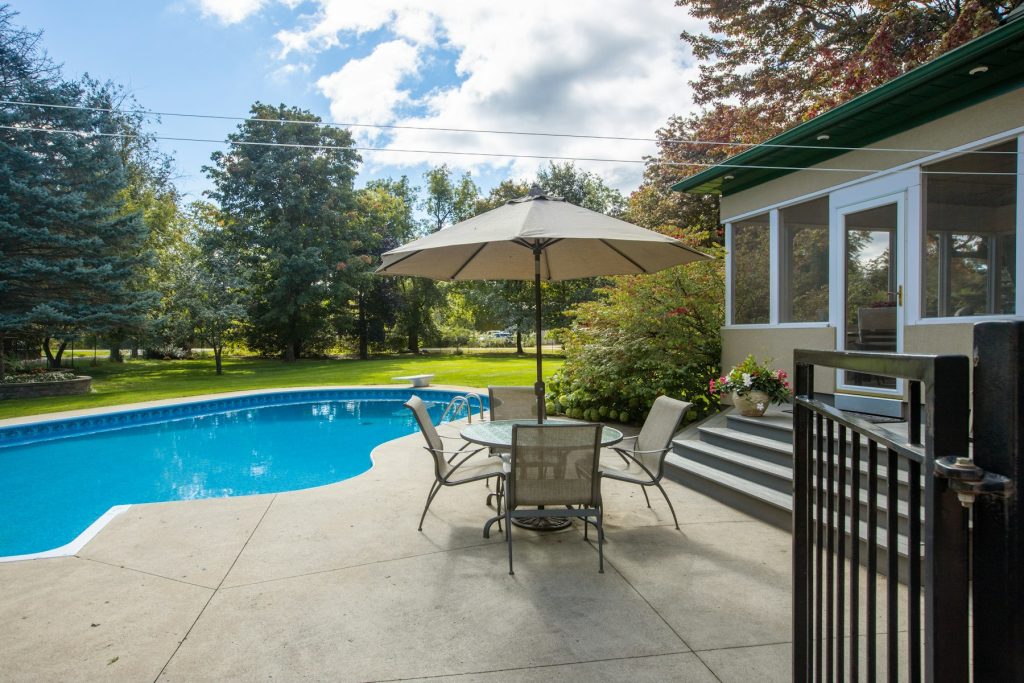 Backyard pool with patio furniture and umbrella