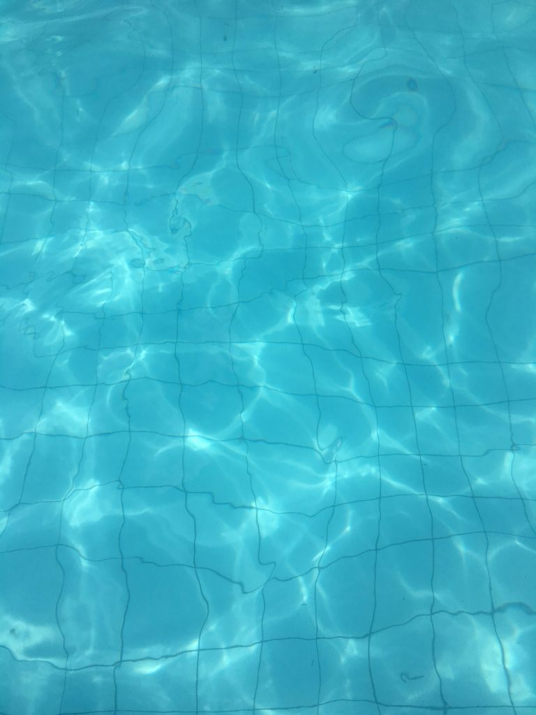 Clear blue pool water rippling in sunlight