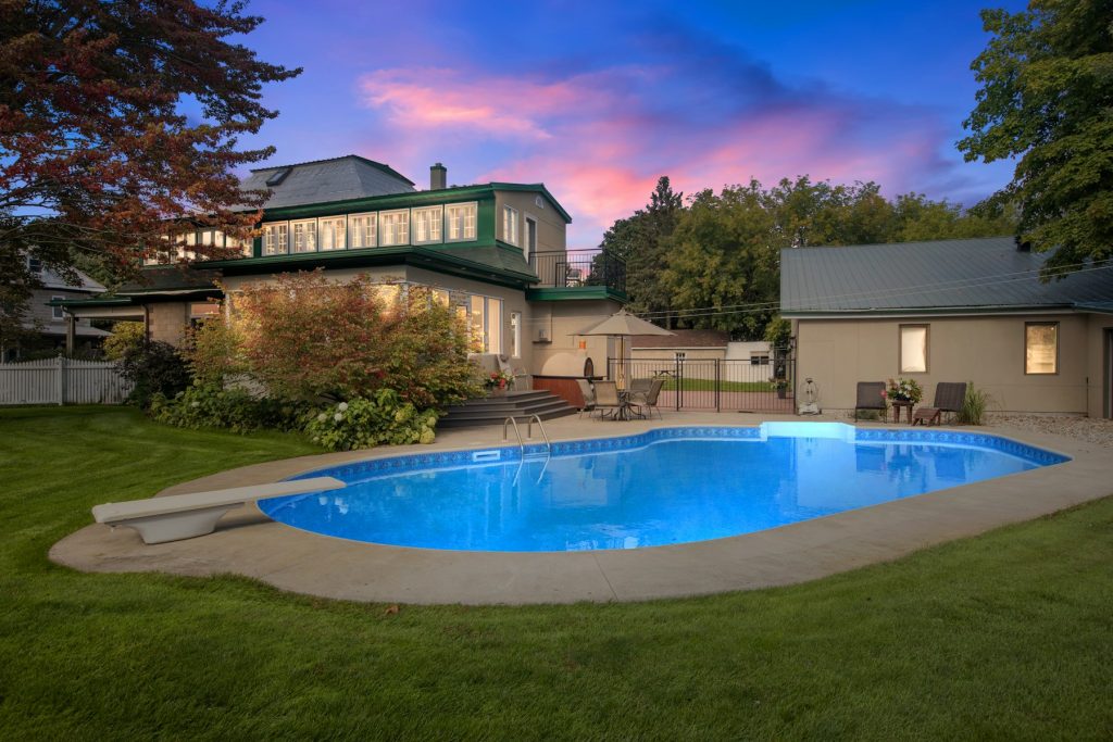 Backyard pool glowing at dusk