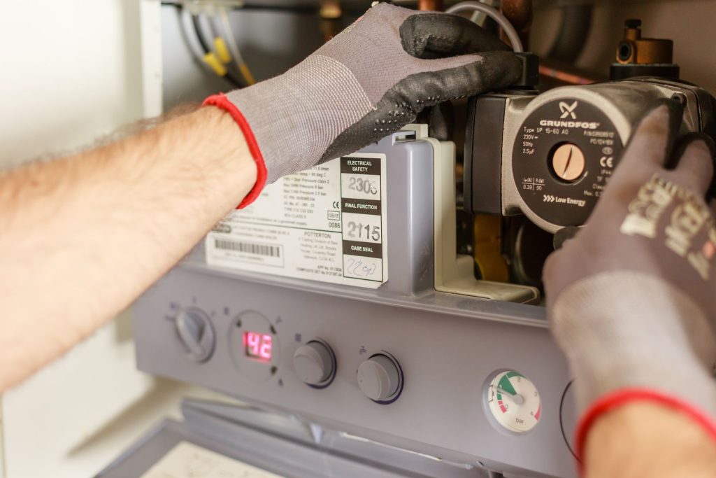 Technician servicing a heater circulator pump and controls