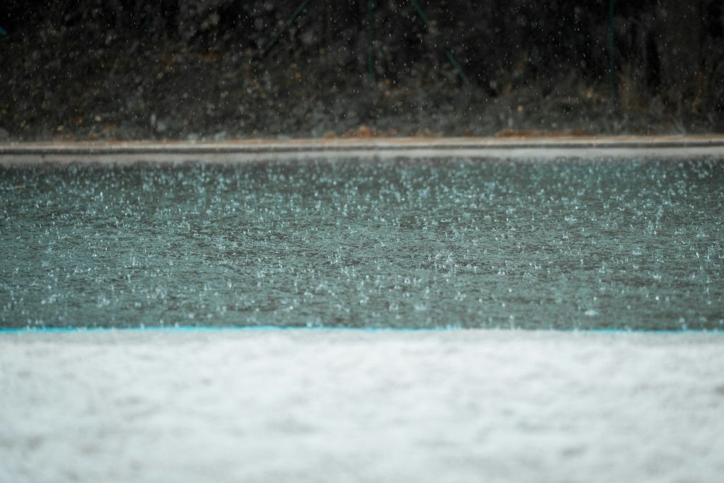 Heavy rain falling on pool water