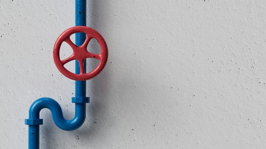 Red shut-off valve on blue plumbing line