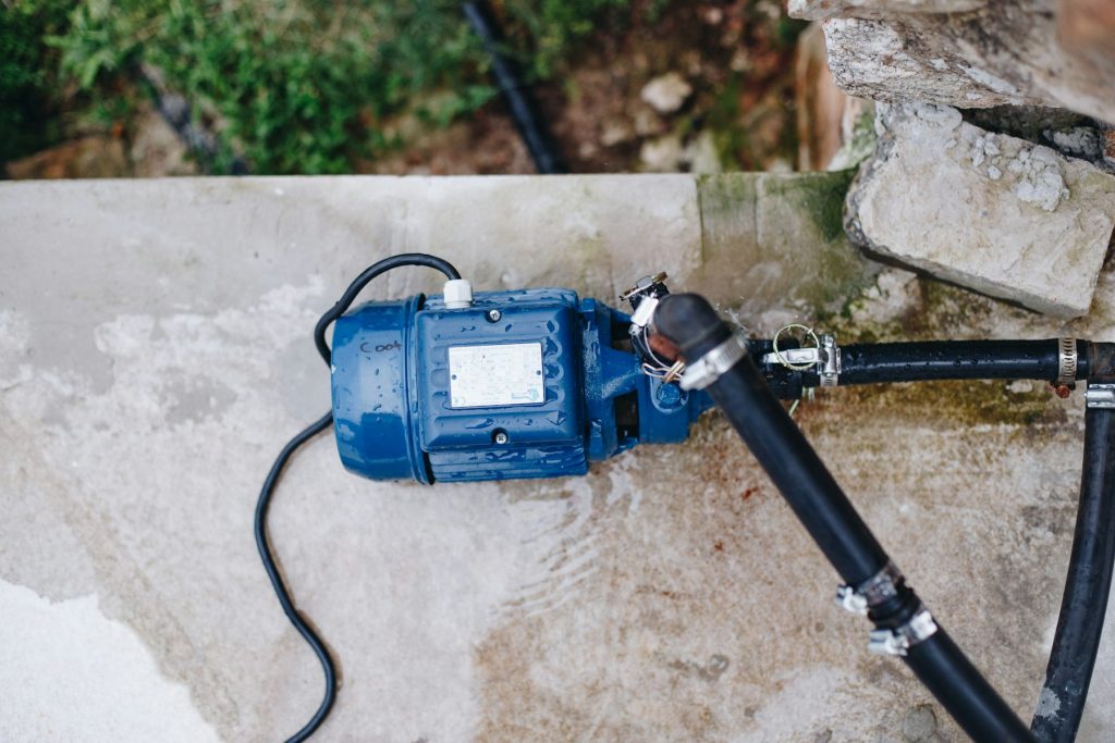 Pool pump motor connected to plumbing on a concrete pad