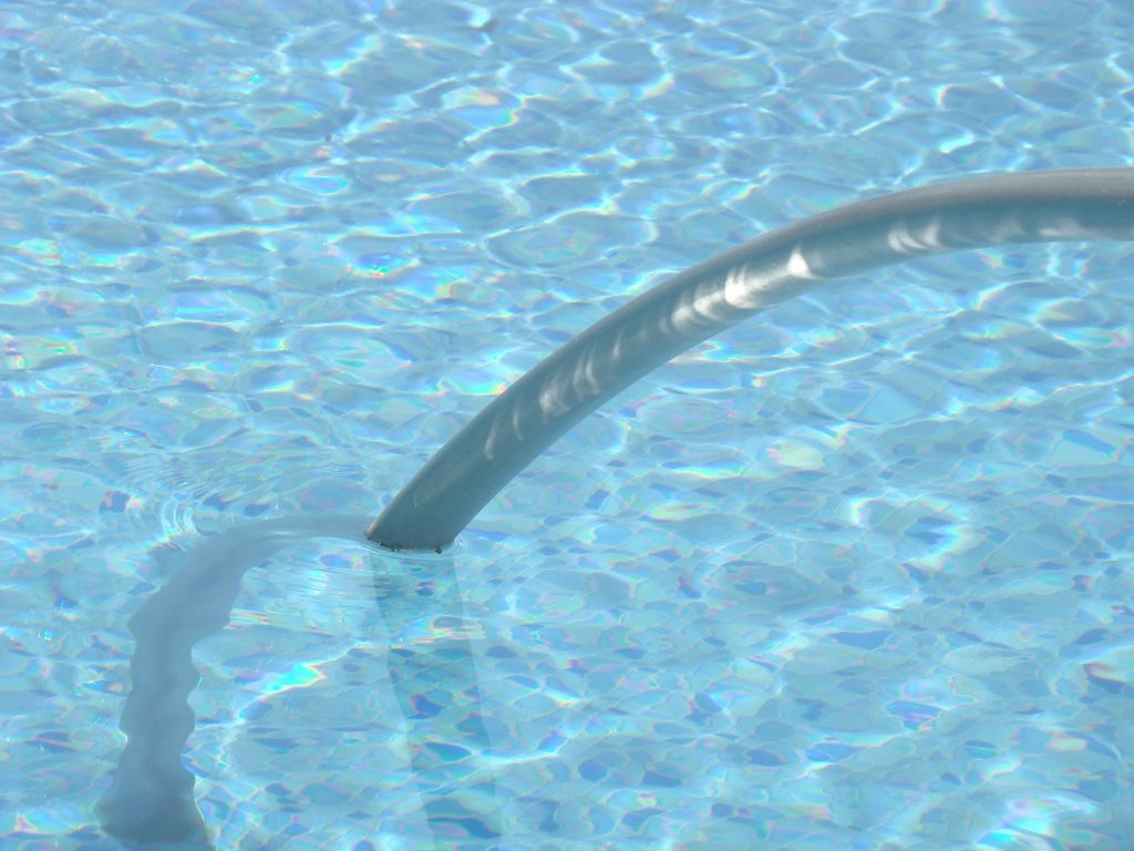 Pool vacuum hose running across the pool floor
