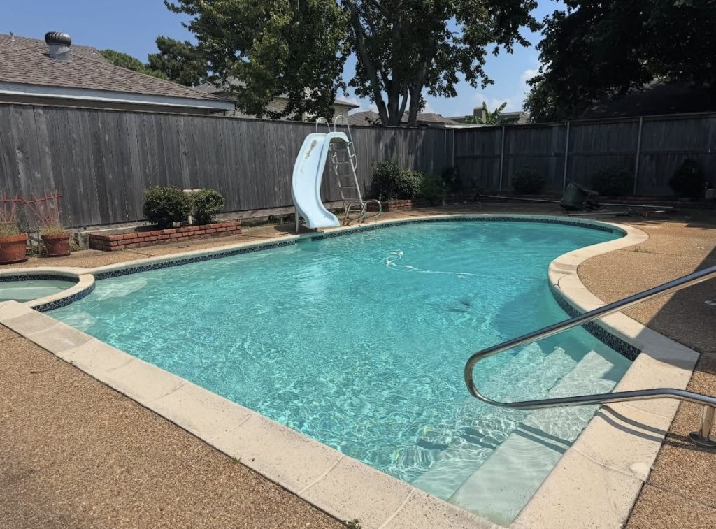 Residential pool with slide, spa, and clean turquoise water